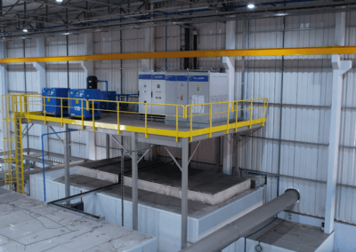 Plataforma elevada com painéis elétricos industriais e guarda-corpo amarelo em ambiente de fabricação da Pellegrin.