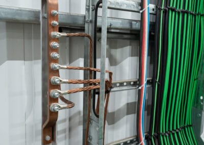 Barramento de equipotencialização BEP com cabos de proteção ao terra fixados e identificados no interior do quadro elétrico.