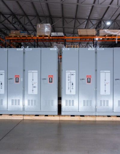 Fileira de painéis elétricos industriais da Pellegrin alinhados no interior de um galpão.