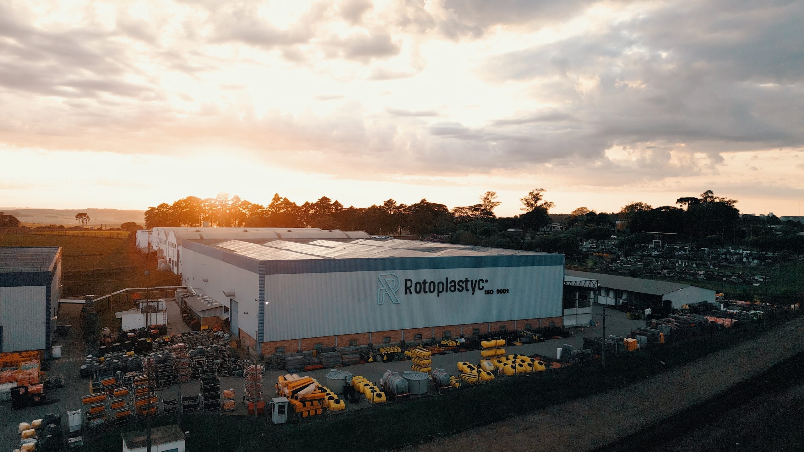 Vista aérea da implantação industrial do case Rotoplastyc com pátio e edificações da planta.